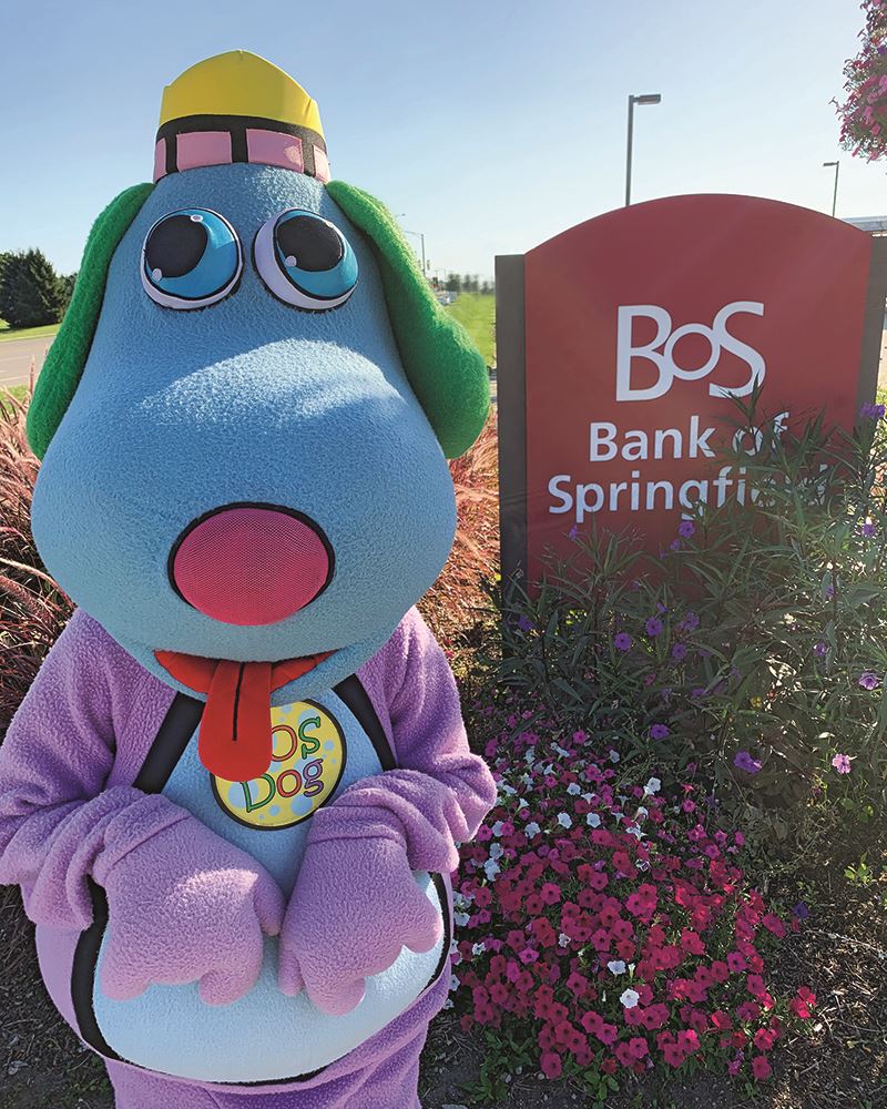 The BOS mascot, BOS Dog, posing next to the Bank of Springfield sign.