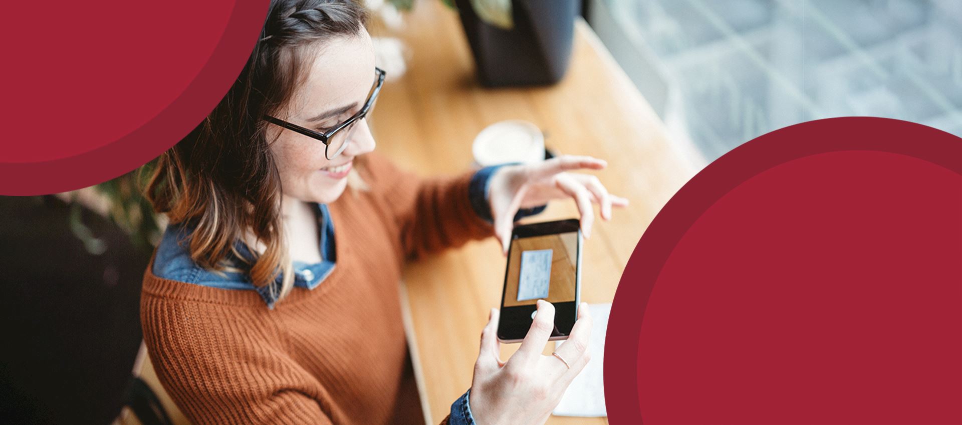 Girl using her cell phone to take a photo of a check for mobile deposit.